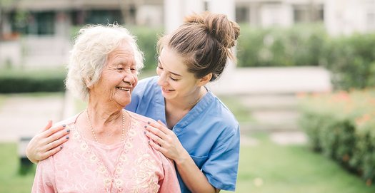 Eine Altenpflegerin im Gespräch mit einer älteren Dame