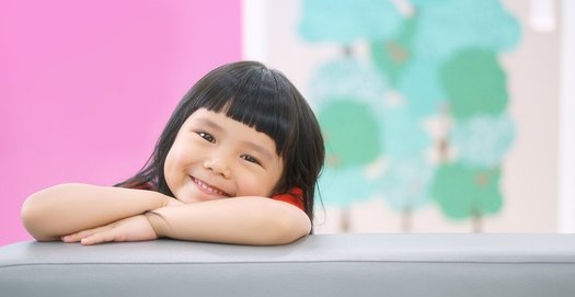 Ein Kind in der Kita lächelt in die Kamera