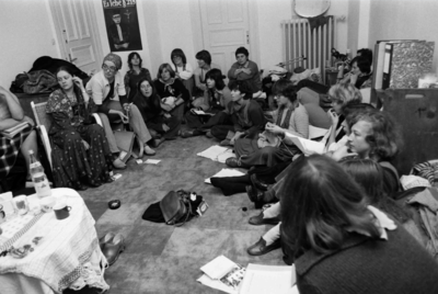 viele Frauen sitzen 1977 auf dem Boden in einem Kreis und besprechen Dinge