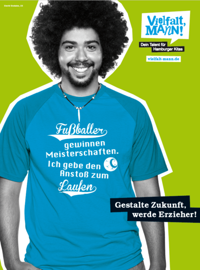 ein junger Erzieher in einem blauen T-Shirt mit der Aufschrfit: Fußballer gewinnen Meisterschaften. Ich geben den Anstoß zum Laufen".