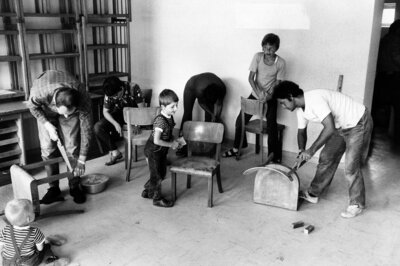 Vier Erwachsene und drei Kider bauen Stühle