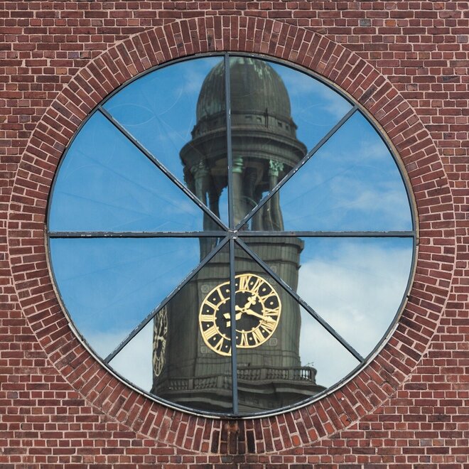 Der Michel spiegelt sich gebrochen in Fenster